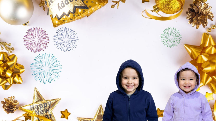 Two children in sensory hoodie with festive new years background of bows and sparkles