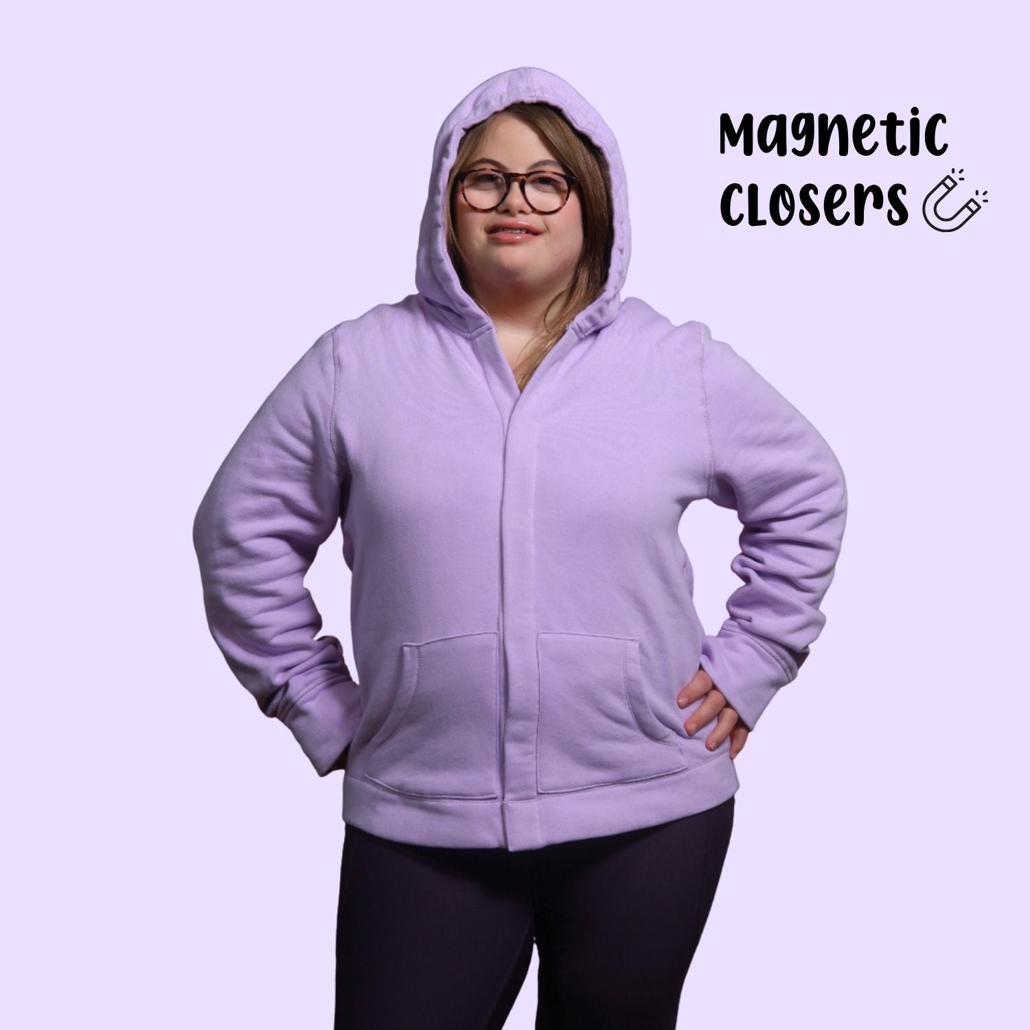 Adult with down syndrome wearing sensory hoodie with sound reducing hood pulled up and magnetic closures shut. 