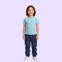 Child wearing a light blue compression t-shirt and dark blue pants with white patterns on a light purple background