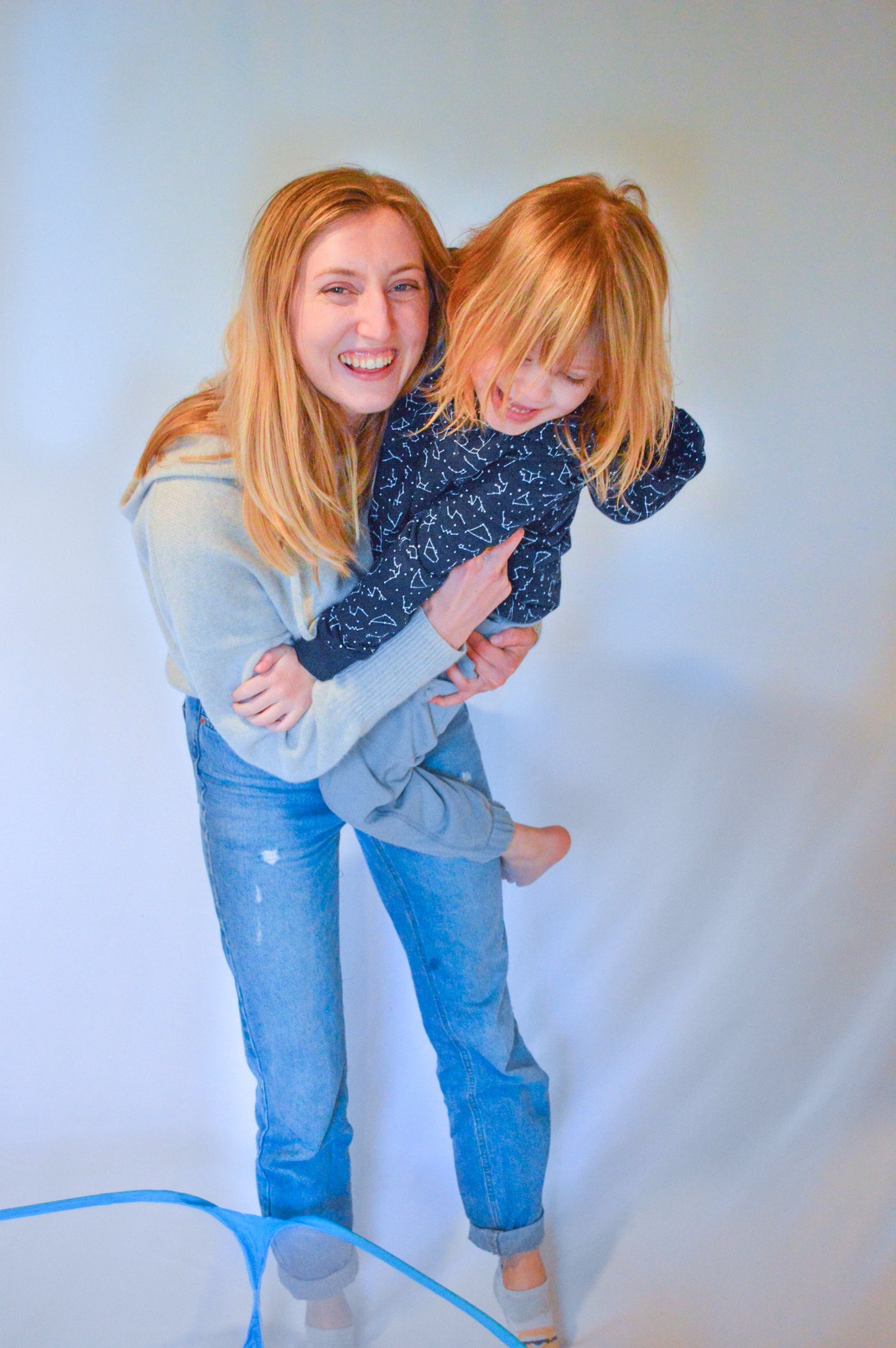 Sense-ational You founder, Julia, holding autistic girl modeling their sensory hoodie and joggers. 