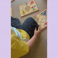 student playing with fidget on jogger pocket with puzzles near by.