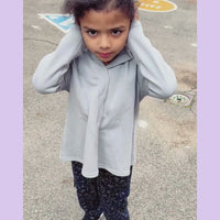Child with sound sensitivity finding relief with sound reducing hood on his sensory hoodie.